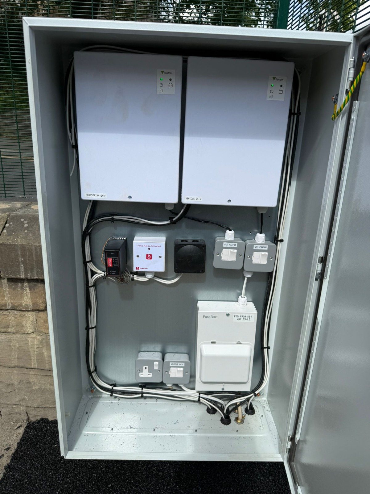 Gate control panel with separate Paxton controllers for the pedestrian and vehicle gates, and a fire relay